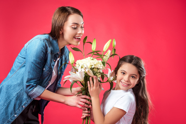 Filha apresentando buquê de flores para a mãe
 - Foto, Imagem