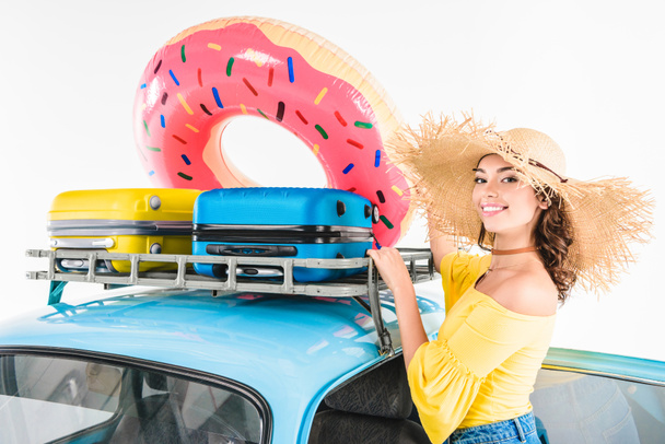 mujer poniendo donut inflable en coche
 - Foto, imagen