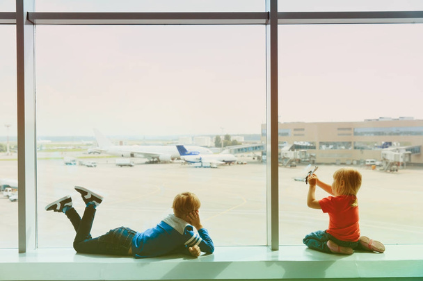 τα παιδιά περιμένουν αεροπλάνο στο αεροδρόμιο - Φωτογραφία, εικόνα