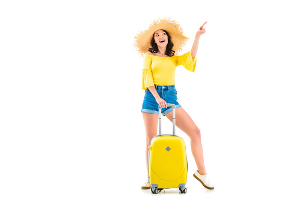 nainen matkatavaroiden kanssa osoittaa ylöspäin
 - Valokuva, kuva