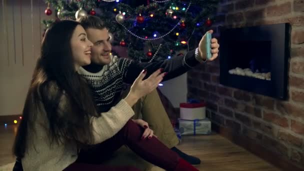 the couple gathered around a Christmas tree, using a tablet - Filmati, video