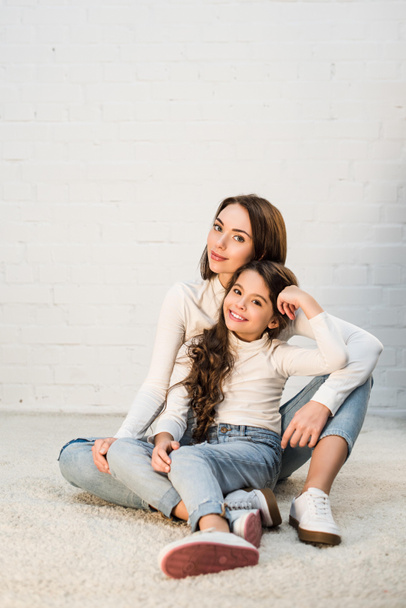 Mutter und Tochter sitzen auf Teppich - Foto, Bild