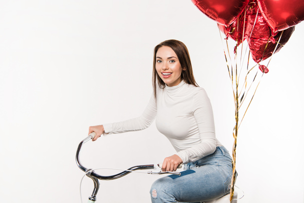 woman sitting on bike with balloons - Foto, imagen