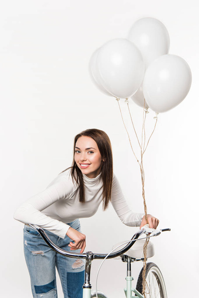woman leaning on bike with balloons - Фото, изображение