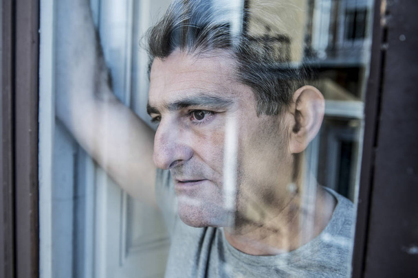 zblízka portrétní 40s smutný a depresivní člověk při pohledu přes w - Fotografie, Obrázek