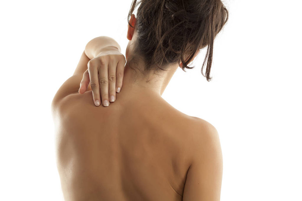 Back view of a woman with pain in her neck and shoulders - Photo, Image