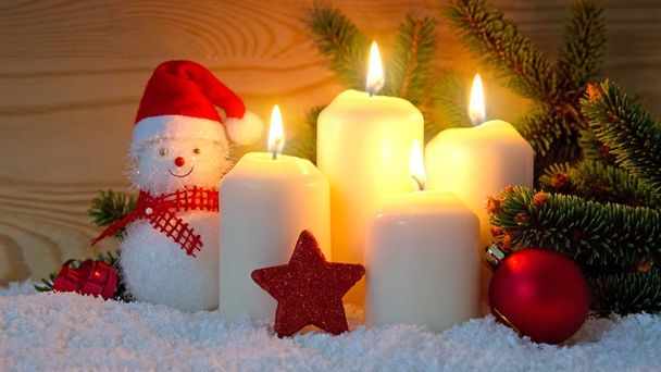 Чотири білі свічки Advent, що горять і сніговик
 . - Фото, зображення
