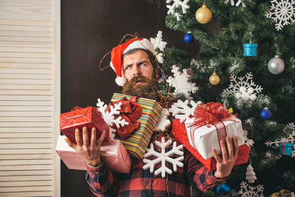 Santa claus man with present box at christmas tree. - Фото, изображение