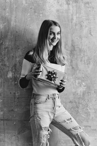 Pretty young happy girl with blond hair holds present box - 写真・画像