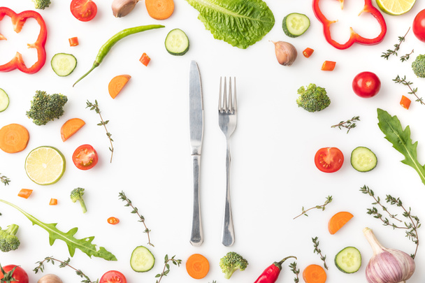カット野菜のサークルにナイフとフォーク - 写真・画像