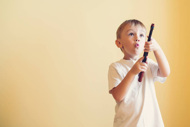 Kleine jongen spelen met speelgoed pistool thuis. - Foto, afbeelding