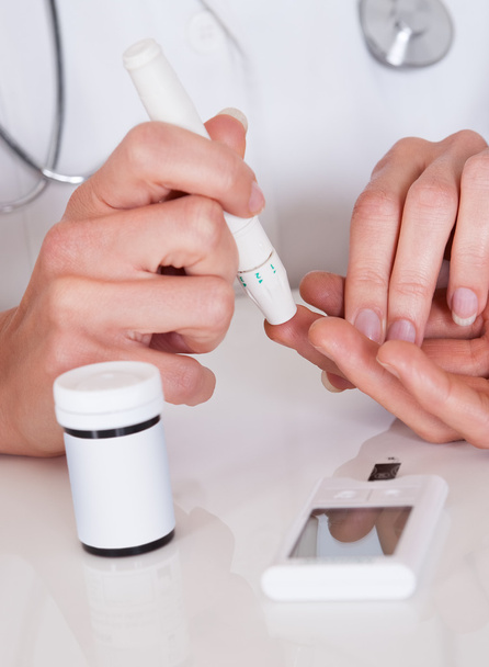 Doctor testing a patients glucose level - Photo, image
