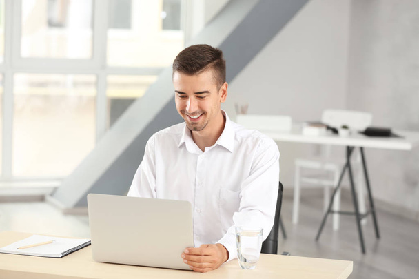 Attractive man with laptop in office - Foto, immagini