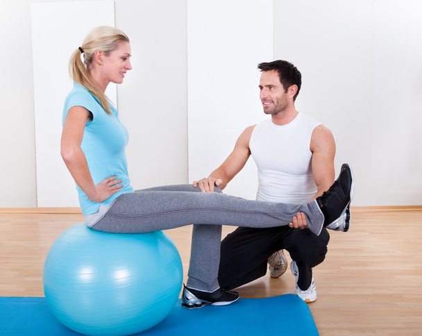Instructor helping a woman with pilates exercises - Φωτογραφία, εικόνα