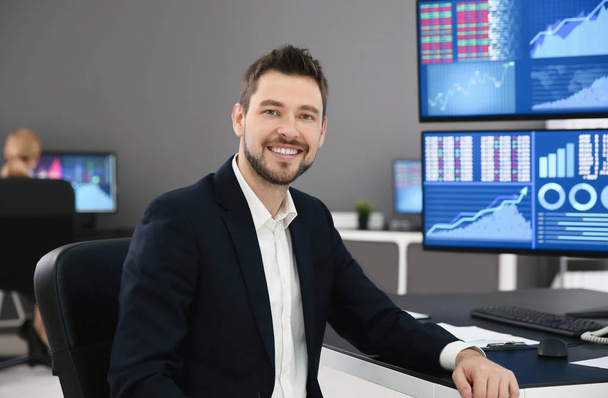 Male stock trader working in office - Foto, afbeelding