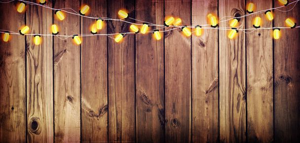 Garland with lights. Old wooden background. Celebratory lights.  - Photo, Image