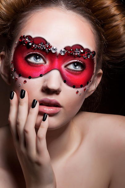 Пофарбовані обличчя. Красива дівчина в червоний карнавальні маски. Маскарад - Фото, зображення