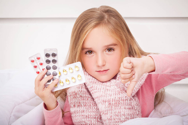 Dívka při pohledu na nachlazení a chřipku pilulky  - Fotografie, Obrázek