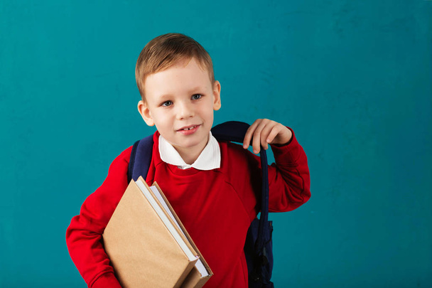 joyeux réfléchi petit écolier en uniforme scolaire avec bac
 - Photo, image