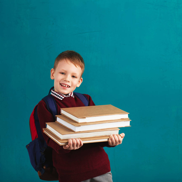 Cheerful thoughtful little school boy in school uniform with bac - Fotó, kép