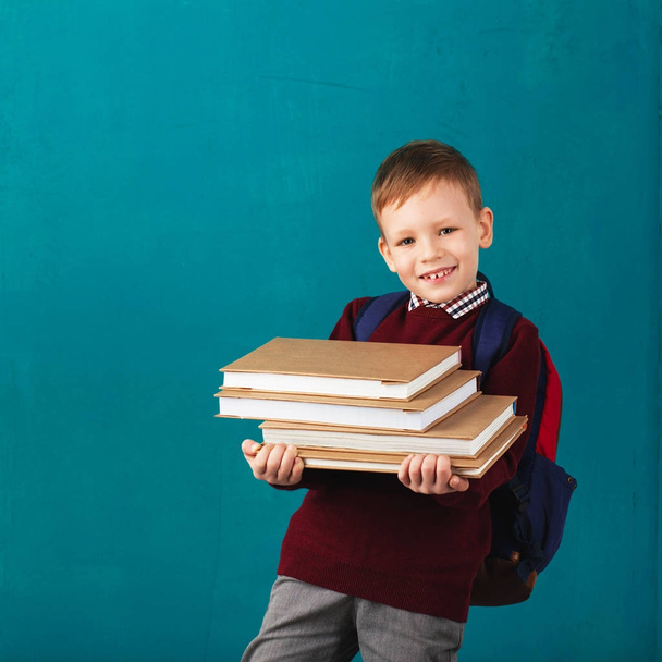 Vrolijke doordachte school jongetje op school uniform met bac - Foto, afbeelding