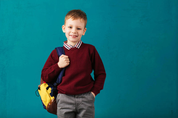 Cheerful thoughtful little school boy in school uniform with big - Foto, imagen