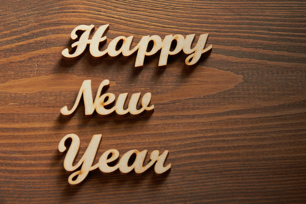 Happy New Year! - A phrase with wooden letters on a wooden background. - Photo, Image
