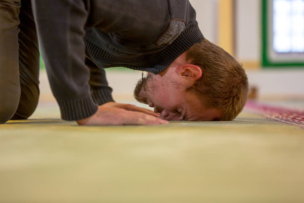 Muslim man praying, putting his forehead and hands on the floor - Fotó, kép