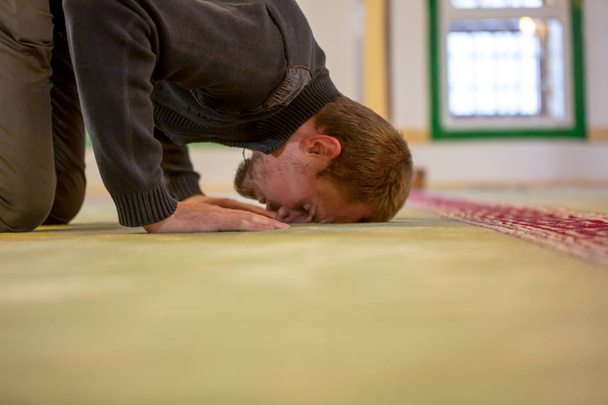 Мусульманських людина молиться, поклавши лоб і руки на поверсі - Фото, зображення