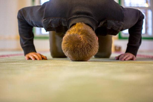 Islamitische man bidden, zijn voorhoofd en de handen op de grond zetten - Foto, afbeelding