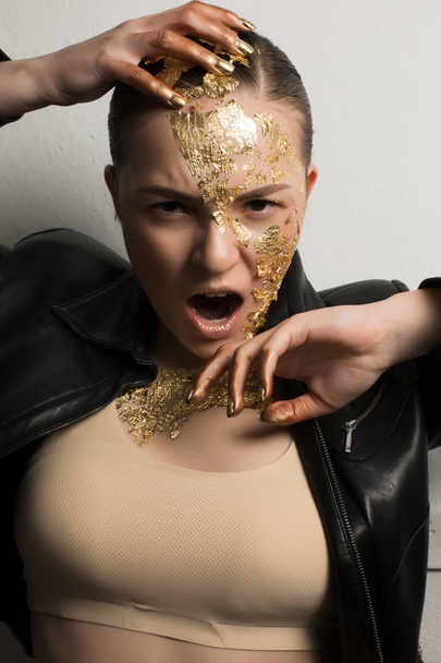 Mulher zangada gritando com folha de ouro em seu rosto, cabelo e pescoço
, - Foto, Imagem