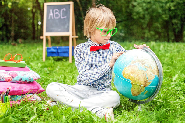 Boy examines the globe. Teaches geography.  - Photo, Image