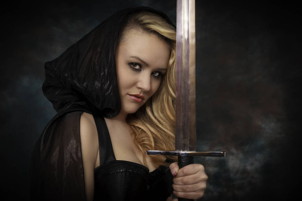young beautiful woman with a sword in the hand in black cape. Am - Foto, Imagem