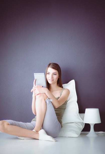 Woman with pc tablet is isolated on grey background - Foto, afbeelding