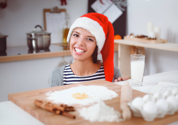 Woman making christmas cookies in the kitchen - Foto, afbeelding