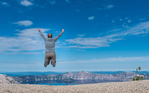 Muž skočí na skalnaté Overlook na Kráterové jezero - Fotografie, Obrázek