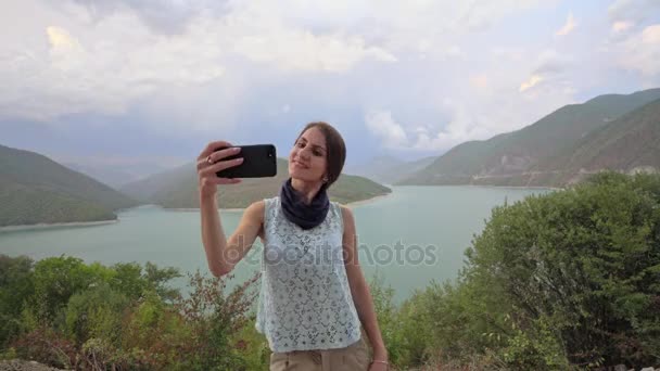 Uma jovem senhora tomando Selfie perto do lago
. - Filmagem, Vídeo