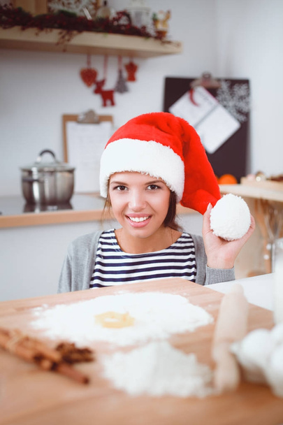Woman making christmas cookies in the kitchen - Foto, afbeelding