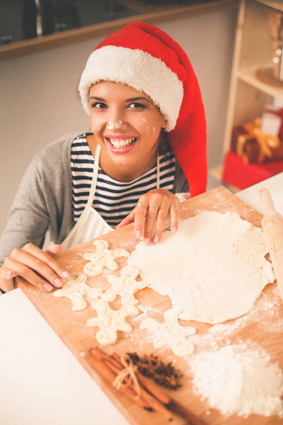 Woman making christmas cookies in the kitchen - Foto, imagen
