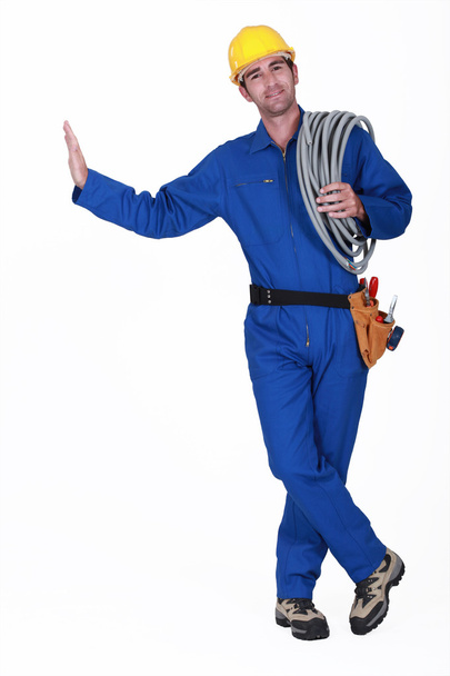 Electrician carrying spool of cable - Photo, image