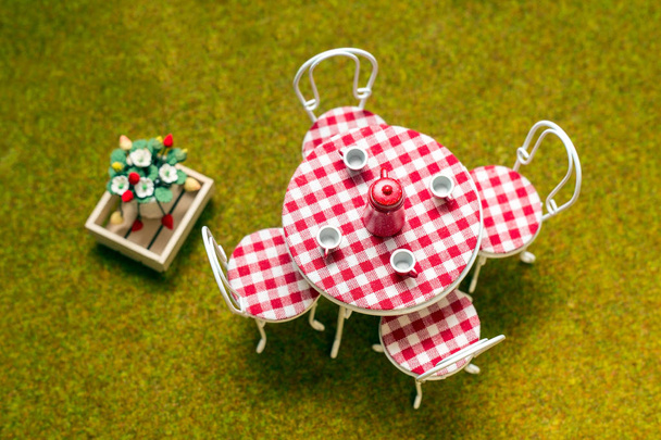 Miniatuur Tuin, een zonnige dag in de tuin installatie, zomer concept in miniatuur, een tafel en stoelen voor een tuinfeest - Foto, afbeelding