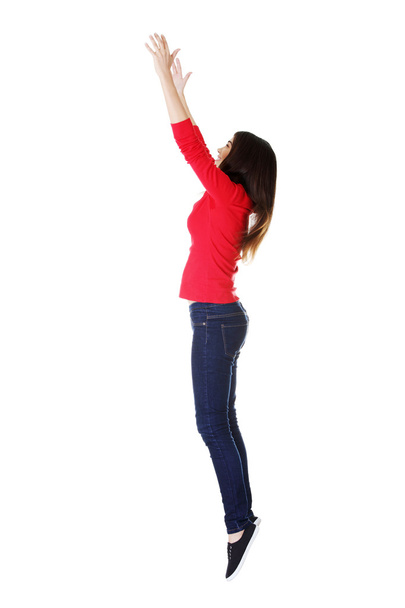 Teen girl jumping in air trying to catch something. - Foto, Imagen