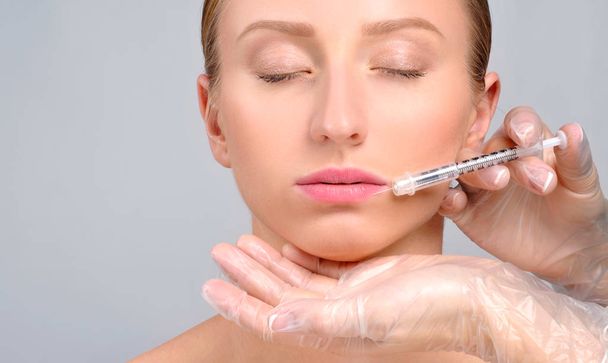 Woman is getting botox injection n lips. Cosmetic Treatment and  - Φωτογραφία, εικόνα