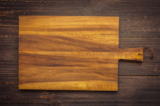 Дошка для різання деревини на дерев'яному фоні з копіювальним простором
 - Фото, зображення
