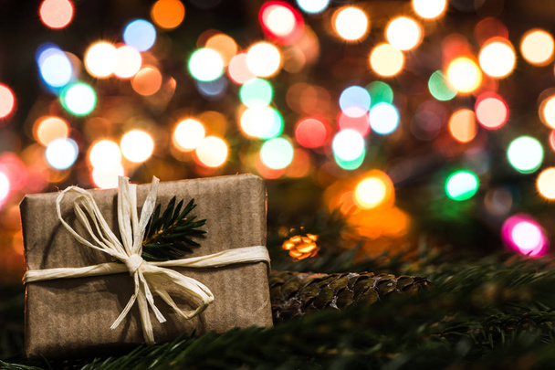 Vánoční dárek, Vánoční pozadí s rozsvícenými světly eve strom a dárkové krabice - Fotografie, Obrázek