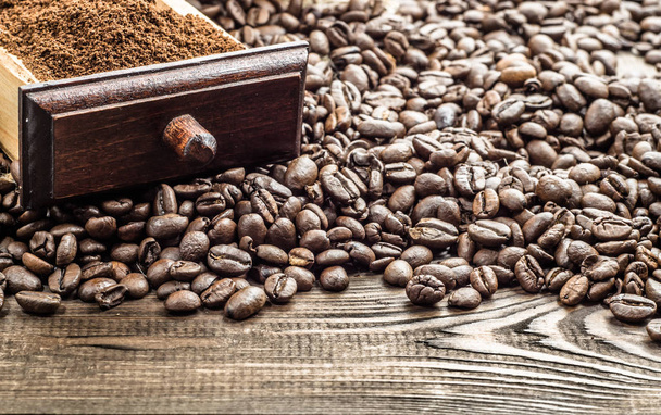 Cajón de café molido y granos de café en saco de yute sobre mesa de madera
 - Foto, Imagen