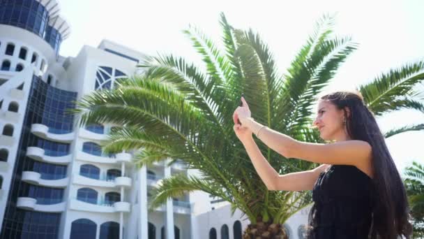 Une jeune femme utilisant un smartphone près de l'hôtel
. - Séquence, vidéo