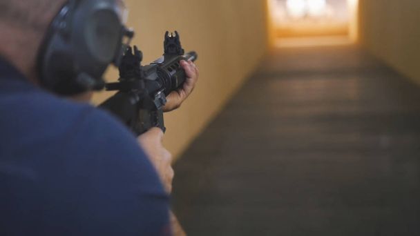 Man instructor have shooting with a Machinegun at the shooting gallery - Photo, Image