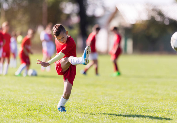 αγόρι κλοτσιές ποδοσφαίρου στον τομέα του αθλητισμού - Φωτογραφία, εικόνα