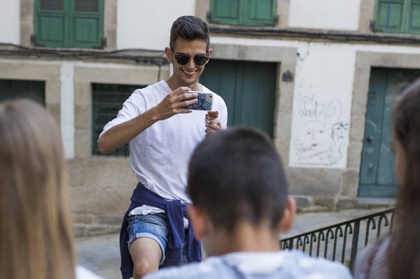молодежная группа с мобильным телефоном на улице
 - Фото, изображение